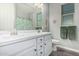Bathroom featuring a double vanity sink, matching mirrors, and leafy green shower curtain at 20595 W Pasadena Ave, Buckeye, AZ 85396