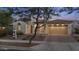 Beautiful home with a desert landscape, arched entryway, and a well-lit two-car garage at 20595 W Pasadena Ave, Buckeye, AZ 85396