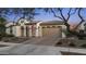 Charming home featuring an arched entryway, neutral stucco, tile roof, and a paved driveway at 20595 W Pasadena Ave, Buckeye, AZ 85396