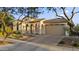 Inviting front exterior featuring an arched entryway, attached two-car garage, and desert landscaping at 20595 W Pasadena Ave, Buckeye, AZ 85396