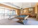 Well-lit game room with two billiards tables and a lounge area with curated wall decor at 20595 W Pasadena Ave, Buckeye, AZ 85396