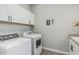 Bright laundry room featuring a washer and dryer, white cabinetry, and decor at 20595 W Pasadena Ave, Buckeye, AZ 85396