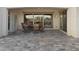 Covered patio with stone floors, dining table and chairs, with sliding glass doors to the interior at 20595 W Pasadena Ave, Buckeye, AZ 85396
