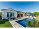 Inviting backyard with a sparkling pool, outdoor kitchen, and covered patio seating area at 20595 W Pasadena Ave, Buckeye, AZ 85396