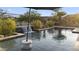 Sparkling pool with modern waterfall feature, bordered by desert plants, promising a refreshing escape at 20595 W Pasadena Ave, Buckeye, AZ 85396