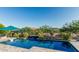 Sparkling pool with waterfall feature and lush landscaping for a serene outdoor retreat at 20595 W Pasadena Ave, Buckeye, AZ 85396
