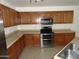 Charming kitchen with lots of wood cabinets, stainless appliances, and tiled flooring at 22632 W Solano Dr, Buckeye, AZ 85326