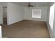 Open living room with neutral carpet, ceiling fan, and bright natural light at 22632 W Solano Dr, Buckeye, AZ 85326