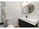 Modern bathroom showcasing a sleek vanity, oval mirror, unique tiling, and contemporary fixtures at 2342 N 40Th Ave, Phoenix, AZ 85009