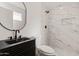 Sleek bathroom featuring a modern black vanity and a glass enclosed shower with elegant marble tile at 2342 N 40Th Ave, Phoenix, AZ 85009