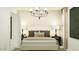 Stylized bedroom with a neutral palette, decorative pillows, lamps, and modern chandelier at 25052 N 174Th Ln, Surprise, AZ 85387