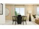 Dining room with round dark wood table, decorative mirror, and large window at 25052 N 174Th Ln, Surprise, AZ 85387