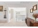 Bright hallway with white walls and carpet flooring, leading to multiple rooms and featuring decorative wall art at 25546 N 164Th Dr, Surprise, AZ 85387