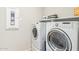 Functional laundry room featuring a washer and dryer set with white appliances and storage shelves at 25546 N 164Th Dr, Surprise, AZ 85387