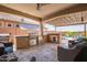 Inviting outdoor kitchen with stainless steel grill, bar seating, and view of the pool area at 25546 N 164Th Dr, Surprise, AZ 85387