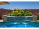 Inviting pool with a waterfall feature, surrounded by lush landscaping at 25546 N 164Th Dr, Surprise, AZ 85387
