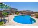Resort-style pool with desert landscaping, patio umbrellas, lounge seating, and solar panels on the roof at 25546 N 164Th Dr, Surprise, AZ 85387