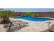Inviting swimming pool with lounge chairs, patio, lush landscaping, and a calming water feature at 25546 N 164Th Dr, Surprise, AZ 85387