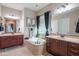 Bright bathroom with dual sink vanities, soaking tub with tile surround, and decorative mirrors at 26333 W Vista North Dr, Buckeye, AZ 85396
