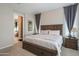 Comfortable primary bedroom with a view to the en suite bathroom featuring neutral walls and carpet flooring at 26333 W Vista North Dr, Buckeye, AZ 85396