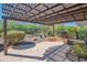 Inviting covered patio with a pergola, seating, and views of desert landscaping at 26333 W Vista North Dr, Buckeye, AZ 85396