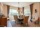 Formal dining room showcasing natural light, modern chandelier, and ample seating at 26333 W Vista North Dr, Buckeye, AZ 85396