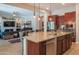 Open kitchen area with an island, sink, seating, and stainless steel appliances at 26333 W Vista North Dr, Buckeye, AZ 85396
