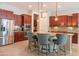 Kitchen with stainless appliances, granite counters, island seating, pendant lights, and tile floors at 26333 W Vista North Dr, Buckeye, AZ 85396