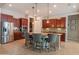 Kitchen with stainless appliances, granite counters, island seating, pendant lights, and tile floors at 26333 W Vista North Dr, Buckeye, AZ 85396