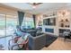 Spacious living room with a large window, a sleek fireplace, built-in shelving, and modern furnishings at 26333 W Vista North Dr, Buckeye, AZ 85396