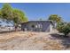 Back view of the house exterior showing a gravel yard and surrounding trees at 2853 W Ohio St, Apache Junction, AZ 85120