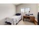 Cozy bedroom with a twin bed, wooden desk, and neutral walls at 2963 S 83Rd St, Mesa, AZ 85212