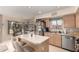This is an eat-in kitchen with an island, stainless steel refrigerator, and light wood cabinetry at 2963 S 83Rd St, Mesa, AZ 85212