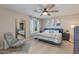 Bedroom with a queen bed, large mirror, accent chair, ceiling fan and natural light at 312 S Hardy Dr # 106, Tempe, AZ 85281