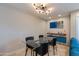 Dining room with a glass table, black chairs, contemporary light fixture, and travertine floors at 312 S Hardy Dr # 106, Tempe, AZ 85281