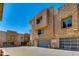 Exterior view of modern townhomes with stone accents and attached garages under a clear, blue sky at 312 S Hardy Dr # 106, Tempe, AZ 85281
