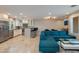 Open-concept living area with modern sectional couch, travertine tile, and kitchen view at 312 S Hardy Dr # 106, Tempe, AZ 85281