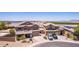 Beautiful aerial view of a two story home with a lake, desert landscaping, and car in the driveway at 36645 W Bilbao St, Maricopa, AZ 85138