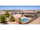 Desert home featuring a swimming pool, sand court, palm trees, and covered patio at 36645 W Bilbao St, Maricopa, AZ 85138