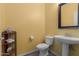 Cozy half bathroom with decorative elements, light yellow walls, and a modern sink and toilet at 36645 W Bilbao St, Maricopa, AZ 85138