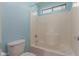 Bright bathroom with a tiled shower-tub combination and a window for natural light at 36645 W Bilbao St, Maricopa, AZ 85138