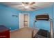 Bedroom features blue walls, carpet, and a treadmill for exercise at 36645 W Bilbao St, Maricopa, AZ 85138