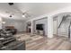 Open-concept living room with modern lighting, a wet bar, and staircase access to the upper level at 36645 W Bilbao St, Maricopa, AZ 85138