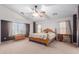 Main bedroom with a king bed, ceiling fan, and large windows for plenty of natural light at 36645 W Bilbao St, Maricopa, AZ 85138