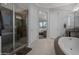 Bright bathroom showcases a glass shower, soaking tub, granite countertops, and elegant tile flooring at 3907 E Carob Dr, Gilbert, AZ 85298