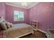 Charming bedroom with lavender walls, a silver chandelier, and a large bed with a tufted headboard at 3907 E Carob Dr, Gilbert, AZ 85298