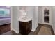 Hallway view with a cabinet, a laundry room door, a decorated wall with art, and a bedroom in the distance at 3907 E Carob Dr, Gilbert, AZ 85298
