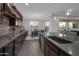 A gourmet kitchen features an island with a sink, granite counters, tile backsplash and stainless steel appliances at 3907 E Carob Dr, Gilbert, AZ 85298