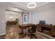 Home office with wood floors, modern lighting, a large desk and an adjoining dining room at 3907 E Carob Dr, Gilbert, AZ 85298