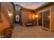 Cozy patio features rustic decor, string lights, and access to the home through a sliding glass door and decorative iron gate at 3907 E Carob Dr, Gilbert, AZ 85298